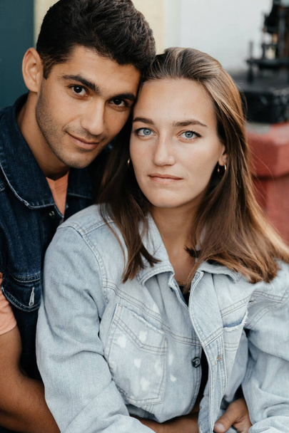 Красива молода пара сидить в джинсовій куртці. Портрет коханців. Пара закоханих у місто. Міська любов
 - Фото, зображення