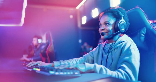 Professional Streamer African young woman cyber gamer studio room with personal computer armchair, keyboard in neon color blur background banner - Photo, Image