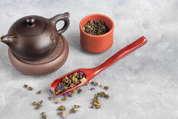 Teezeremonie. Chinesisches Pu-Äh in einer Schüssel. Im Hintergrund eine braune Teekanne und Teeblätter. Kopierraum. - Foto, Bild