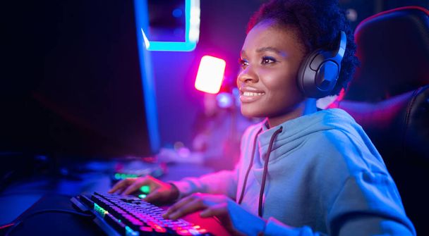 Portrait Gamer African American beautiful woman play online games computer, streamer neon room banner - Photo, Image