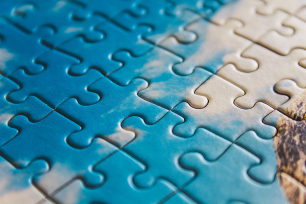Quebra-cabeças. Closeup de peices de quebra-cabeça azul. Foto conceitual com foco no quebra-cabeça concluído - Foto, Imagem