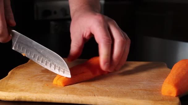 rebanando zanahorias. un hombre corta zanahorias en cubos con un cuchillo. - Imágenes, Vídeo