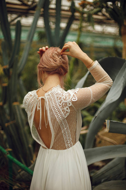 молодая девушка стоит спиной в белом платье и приколоть волосы боке эффект - Фото, изображение