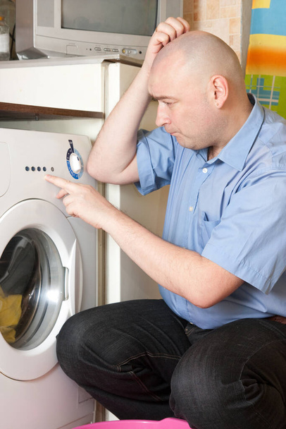  Adult  men loading the washing machine. Cleaning and Laundry - Photo, Image