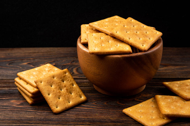 Sušenky Cracker na tmavém dřevěném pozadí. - Fotografie, Obrázek