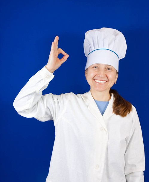 Retrato de cozinheira sênior sobre azul - Foto, Imagem