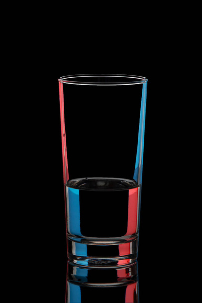 Glass with colored highlights on a black background - Photo, Image