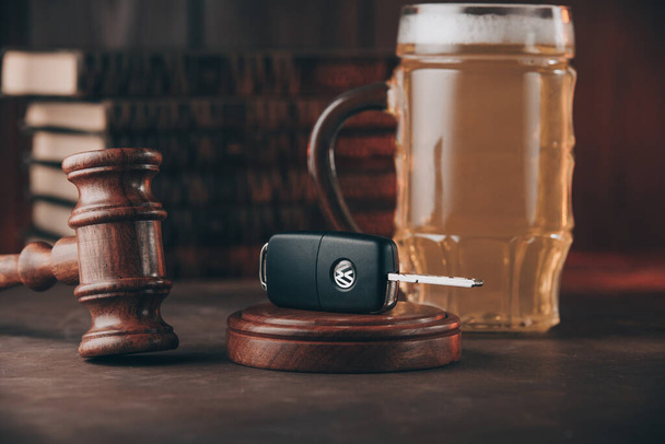 Bir bardak bira, araba anahtarları ve tahta masadaki yargıç tokmağı. Alkol ve araba kazaları kavramı - Fotoğraf, Görsel