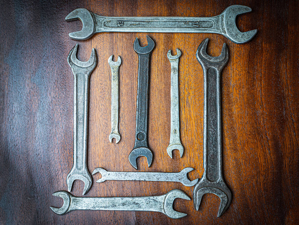 Clés anciennes en métal pour serrer les écrous sur un fond brun bois - Photo, image