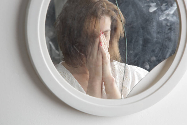 Reflejo de la cara de una mujer en un espejo roto. Depresión, ansiedad, fobia, suicidio y concepto de salud mental. - Foto, imagen