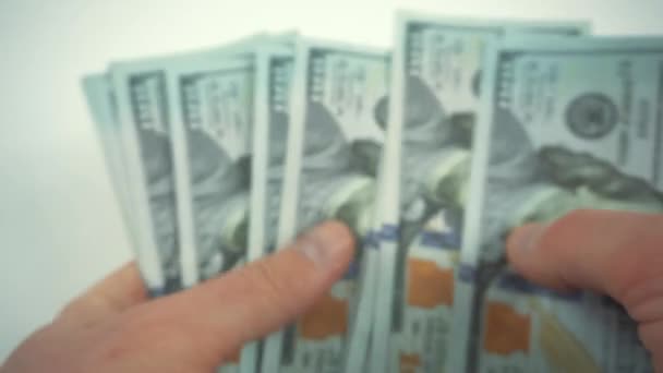 Vídeo borroso del hombre contando dólares sobre fondo blanco - Metraje, vídeo