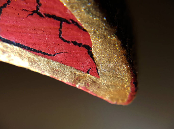Un pétale rouge avec des bordures dorées vues très près de l'objet - Photo, image
