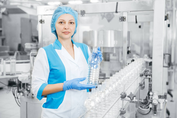 Arbeiterinnen kontrollieren Produktionslinie Fabrikmilchgetränke in Plastikflasche - Foto, Bild