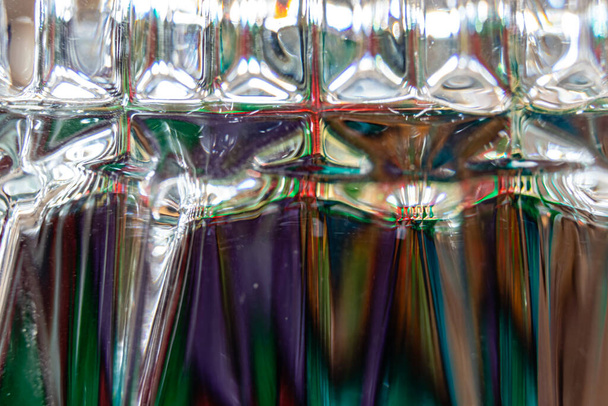 Belos padrões de cores e ângulos de luz vistos muito perto em um copo de uísque invertido - Foto, Imagem