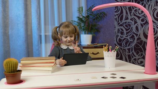 Дівчина робить домашнє завдання онлайн з вчителем, використовуючи цифровий планшетний комп'ютер вдома, дистанційне навчання
 - Фото, зображення