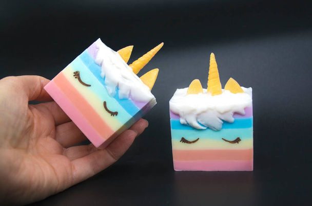 Woman hand holding bar of handmade rainbow unicorn colorful soap. Healthy lifestyle, home concept. keeping hands clean. - Photo, Image