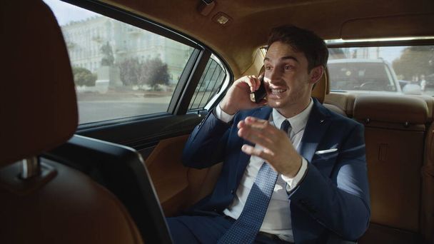 Homme d'affaires souriant parlant sur le téléphone portable à l'intérieur de la voiture d'affaires. - Photo, image