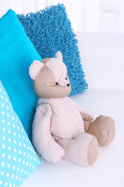 Bear toy with pillows on sofa - Φωτογραφία, εικόνα