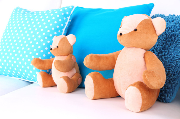 Two bears toy with pillows on sofa - Фото, зображення