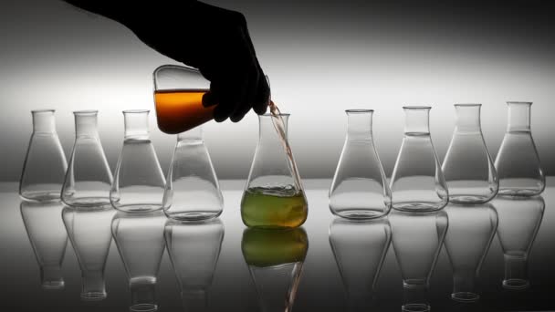 Pouring orange liquid into laboratory flask. - Footage, Video