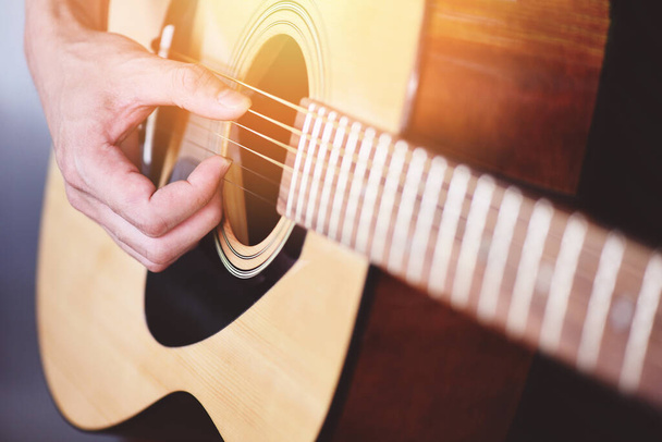 Home hobbies concept, Man hands playing acoustic guitar, close-up guitar player Музыкальный инструмент для отдыха или hobby passion - Фото, изображение