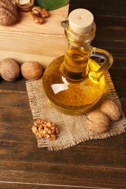 Walnut oil and nuts on wooden table - Valokuva, kuva