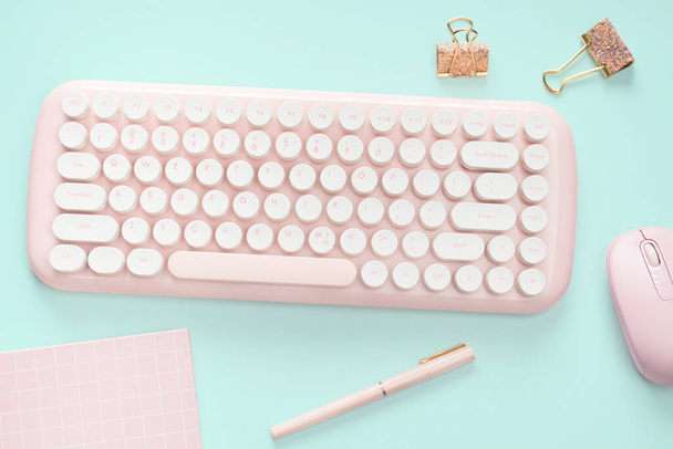 flach liegend rosafarbener Computer und Schreibwaren auf mintgrünem Pastell-Boden - Foto, Bild