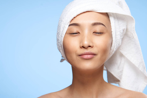 Femme asiatique épaules nues et une serviette sur sa tête gros plan - Photo, image