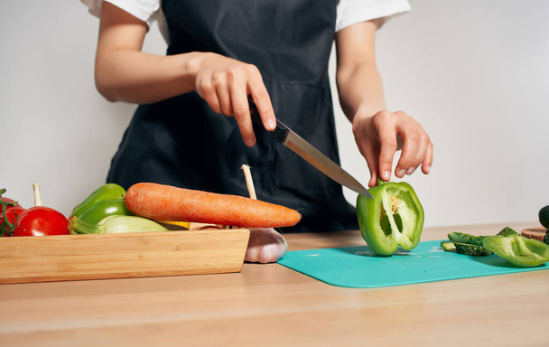料理健康食品キッチン黒エプロン野菜を切断 - 写真・画像