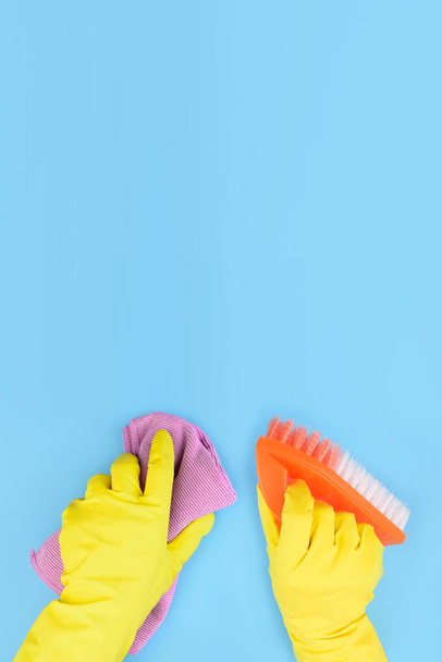 Mains dans les gants jaunes avec brosse et chiffon plan vertical : concept de nettoyage - Photo, image