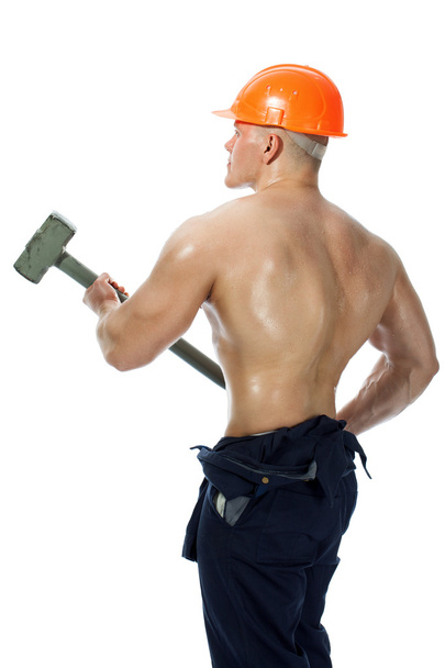Young and handsome builder with a sledgehammer and sexy body - Foto, immagini