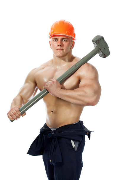 Young and handsome builder with a sledgehammer and sexy body - Fotó, kép