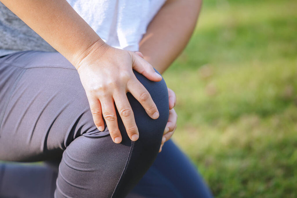 Close-up hand vrouw aanraken pijnlijke knie. Oudere met artrose. Ongeluk vallen kniel pijn van de oefening.  - Foto, afbeelding