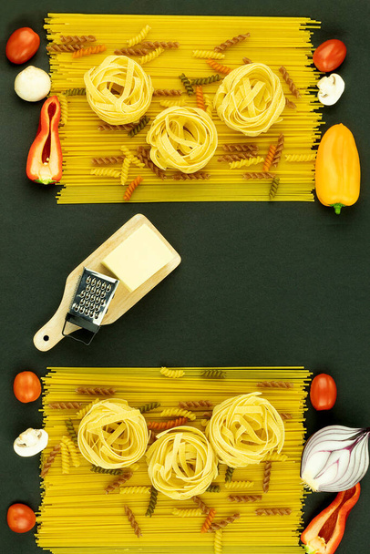 Kontekst układu do gotowania, makaron i warzywa, rozłożone na stole. Na stole znajdują się różne rodzaje makaronów. Miejsce na tekst - Zdjęcie, obraz