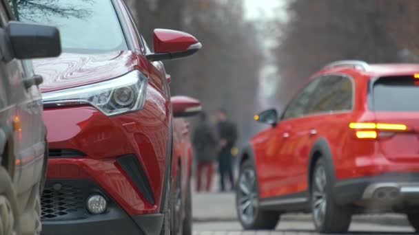 Auto 's geparkeerd op een rij aan de straatkant van een stad. - Video