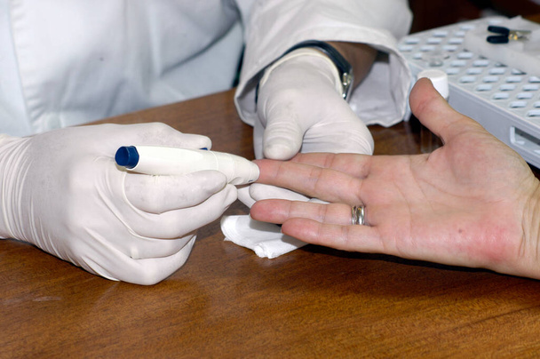 a doctor with gloves does a blood test on a patient - Photo, Image
