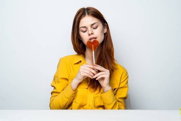 Cheerful pretty woman holding heart-shaped lollipop owner - Photo, Image