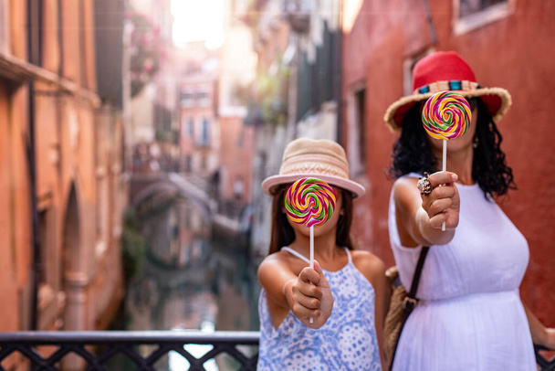 Toeristische familieleden hebben plezier met lolly 's in Venetië Italië. Familie reis concept.  - Foto, afbeelding