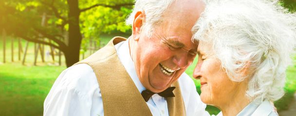 Happy senior couple love story. Old couple is walking in the green park. Grandmother and grandfather laughing. Elderly people lifestyle. Together Pensioners. - Photo, Image