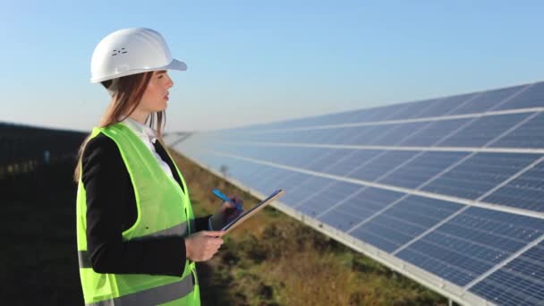 Ženský inženýr zapisuje data do dokumentu. Kontroluje solární panely. 4K - Záběry, video