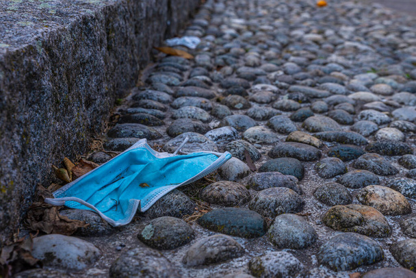 Blue surgical mask, thrown along a country road. Pollution and rudeness. - Photo, Image