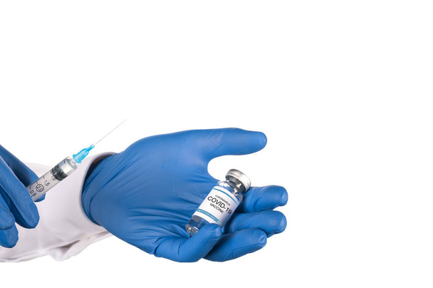 Ο γιατρός αντλεί το εμβόλιο του κορωναϊού από ένα γυάλινο φιαλίδιο με μια σύριγγα. απομονωμένη. αντίγραφο χώρου - Φωτογραφία, εικόνα