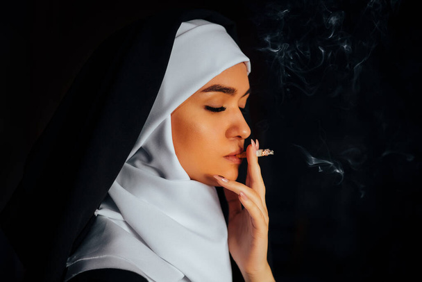 Nonne fumeuse. Portrait d'une jeune religieuse fumeuse, - Photo, image