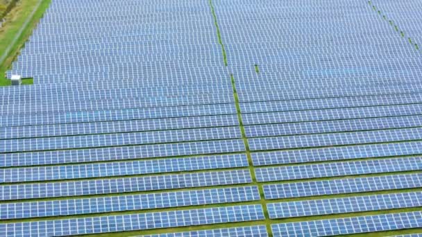 Luchtfoto van zonnecentrale op groen veld. Elektrische panelen voor het opwekken van schone ecologische energie. - Video