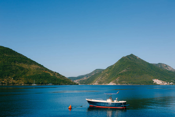Um barco de madeira de pesca azul ancorado na Baía de Kotor, perto da cidade de Perast, no Montenegro. - Foto, Imagem