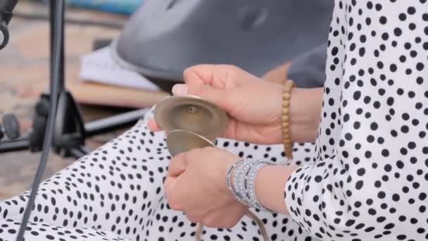 Moción lenta: manos de mujer jugando pequeños platillos indios - manjira: de cerca - Metraje, vídeo