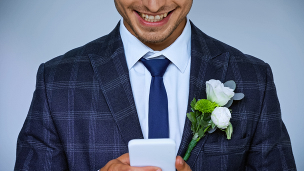 Mutlu damadın mavi renkte izole edilmiş akıllı telefondaki sohbetinin kırpılmış görüntüsü. - Fotoğraf, Görsel