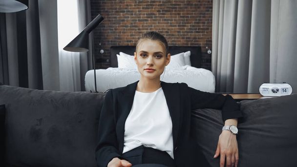 businesswoman in formal wear sitting on sofa in hotel - Foto, Imagem