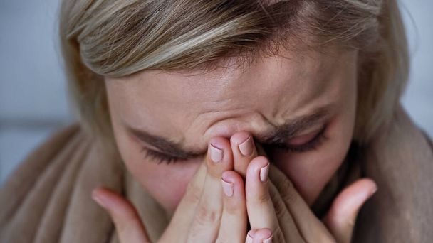 close up view of sick woman sneezing and covering nose with hands - Foto, Imagen