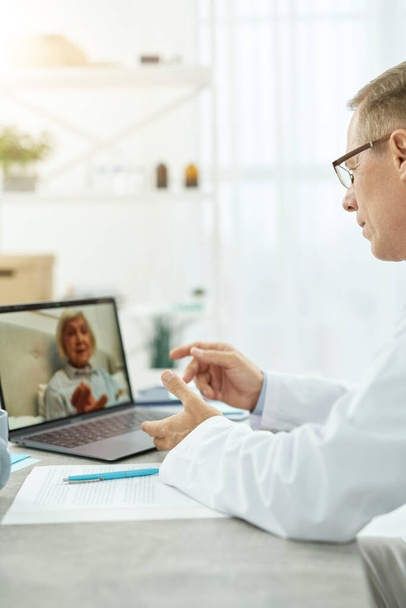 Médecin parlant avec le patient par appel vidéo à la clinique - Photo, image